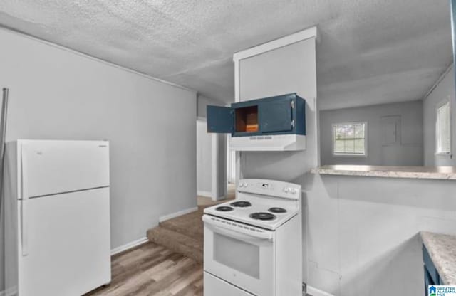 kitchen featuring blue cabinets, white cabinetry, a textured ceiling, white appliances, and light hardwood / wood-style flooring