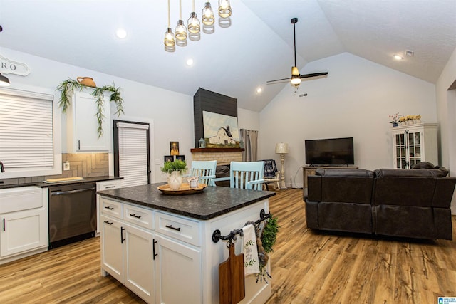 kitchen featuring white cabinetry, light wood-type flooring, lofted ceiling, dishwasher, and pendant lighting