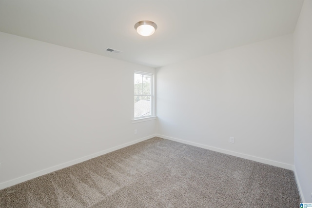 spare room featuring baseboards, visible vents, and carpet flooring