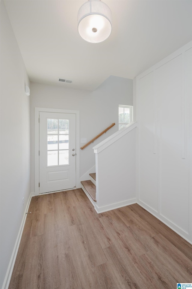 interior space featuring plenty of natural light, baseboards, visible vents, and wood finished floors