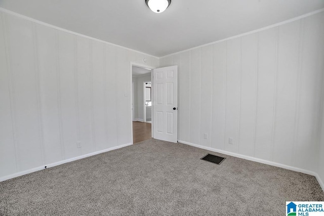 unfurnished room featuring ornamental molding and carpet floors