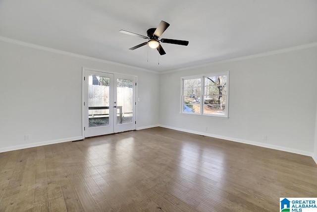 empty room with ornamental molding, ceiling fan, french doors, and dark wood-type flooring