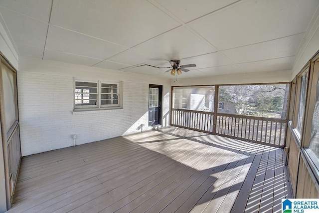 unfurnished sunroom with ceiling fan