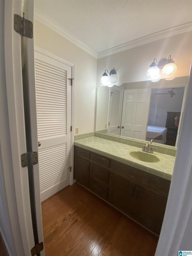 bathroom featuring vanity, ornamental molding, and wood finished floors