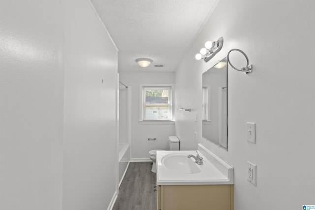 bathroom featuring a textured ceiling, wood-type flooring, vanity, and toilet