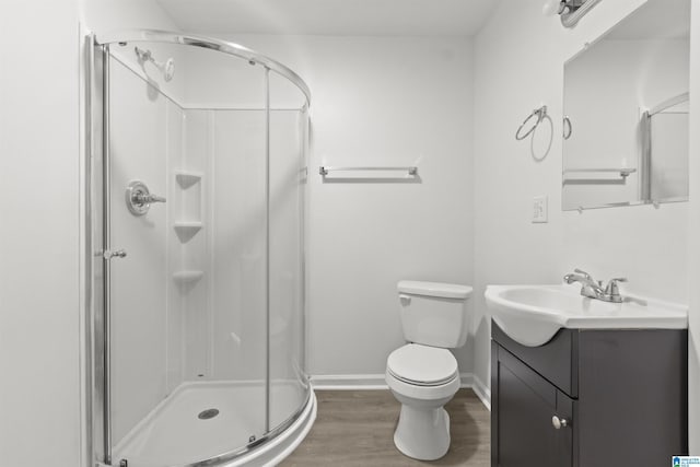 bathroom featuring wood-type flooring, walk in shower, vanity, and toilet