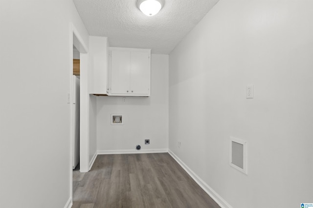 washroom with electric dryer hookup, washer hookup, a textured ceiling, cabinets, and light wood-type flooring