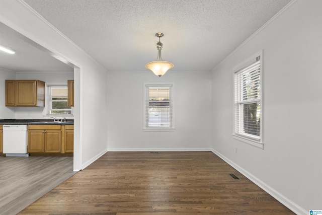 unfurnished dining area featuring plenty of natural light, a textured ceiling, and dark hardwood / wood-style floors