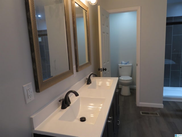 bathroom with wood-type flooring, vanity, and toilet