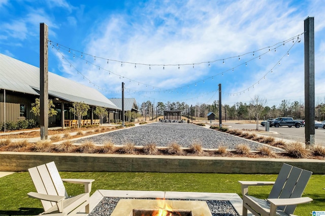 surrounding community with an outdoor fire pit and a lawn