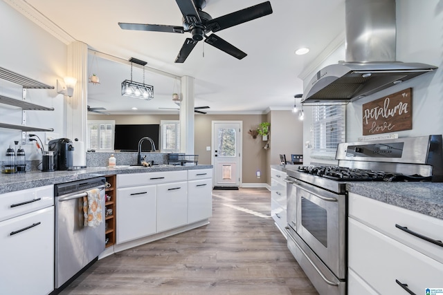 kitchen featuring pendant lighting, island exhaust hood, white cabinetry, light hardwood / wood-style flooring, and appliances with stainless steel finishes