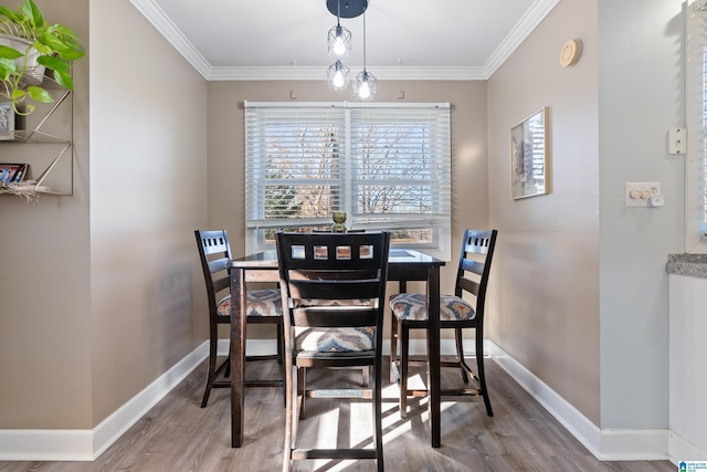 dining room with ornamental molding and hardwood / wood-style flooring