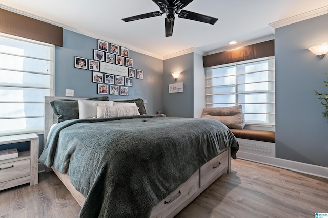 bedroom with ceiling fan, multiple windows, hardwood / wood-style floors, and crown molding