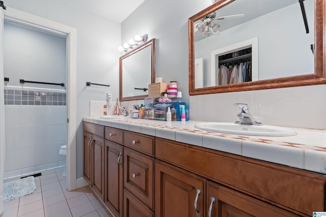 bathroom featuring tile walls, toilet, vanity, and tile patterned flooring