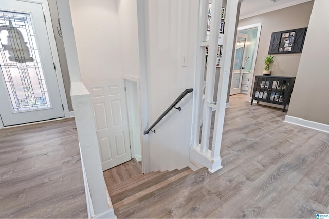 stairway featuring crown molding and hardwood / wood-style floors