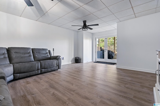 living room featuring ceiling fan, wood-type flooring, a paneled ceiling, and french doors