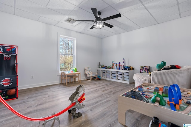 recreation room with hardwood / wood-style flooring, a paneled ceiling, and ceiling fan