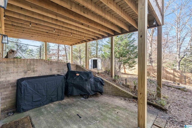 view of patio with a shed and area for grilling