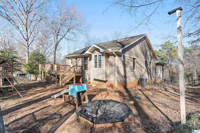 rear view of property featuring a wooden deck and cooling unit