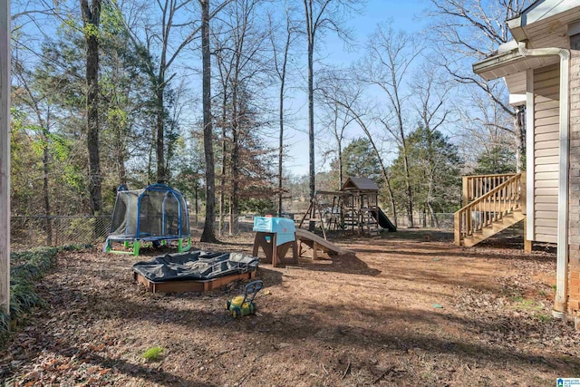 view of yard featuring a trampoline and a playground