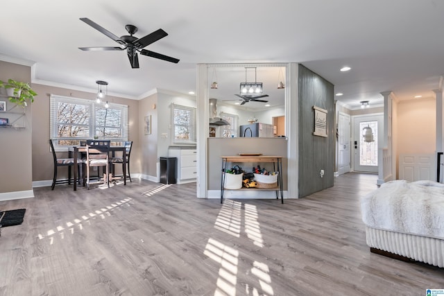 living room with ceiling fan, wood-type flooring, and ornamental molding