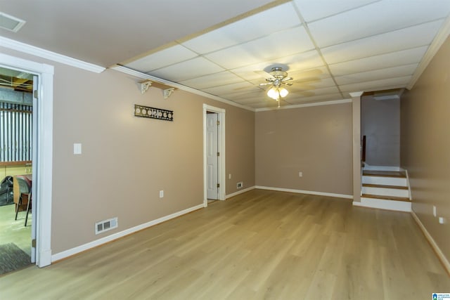 basement featuring ceiling fan, a drop ceiling, light wood-type flooring, and crown molding