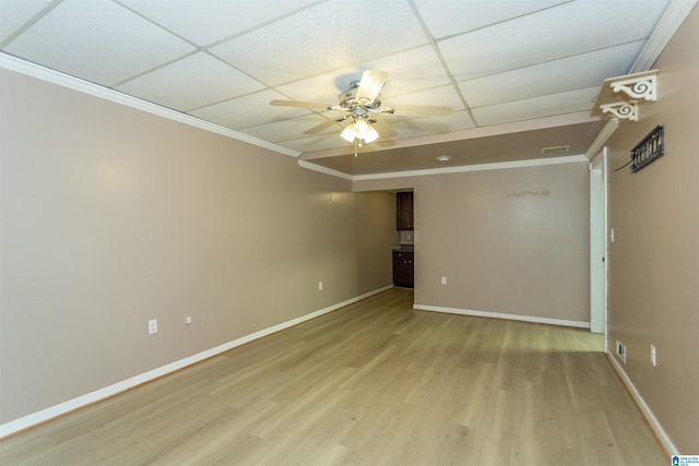 empty room featuring light hardwood / wood-style floors, a paneled ceiling, ornamental molding, and ceiling fan