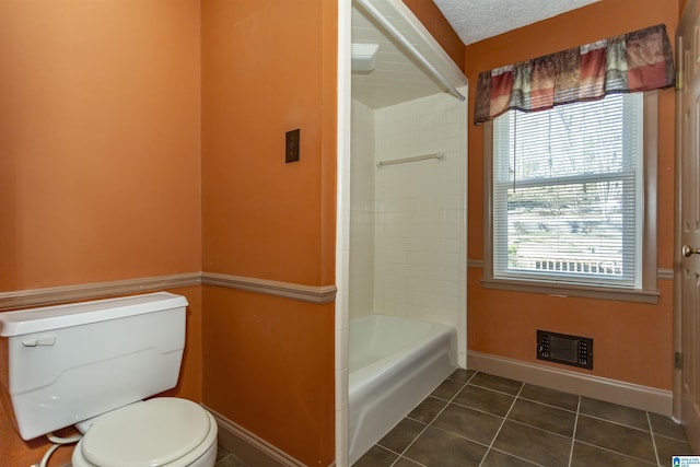 bathroom featuring toilet, tile patterned floors, and a textured ceiling