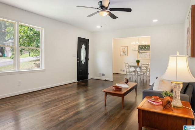 living room with dark hardwood / wood-style floors and ceiling fan with notable chandelier