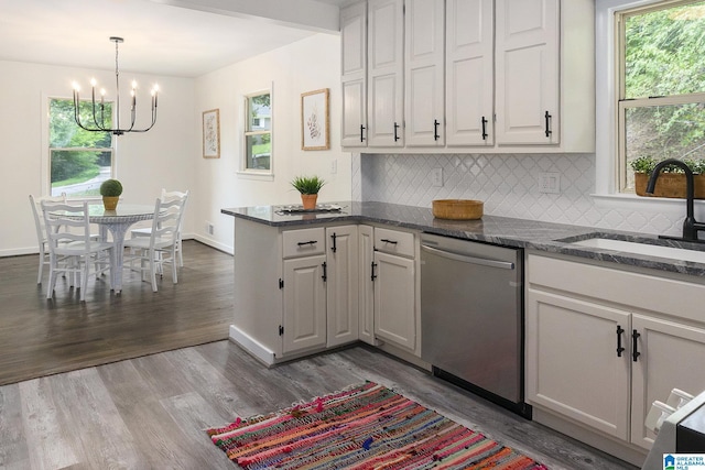 kitchen with dishwasher, a notable chandelier, hardwood / wood-style floors, white cabinets, and sink