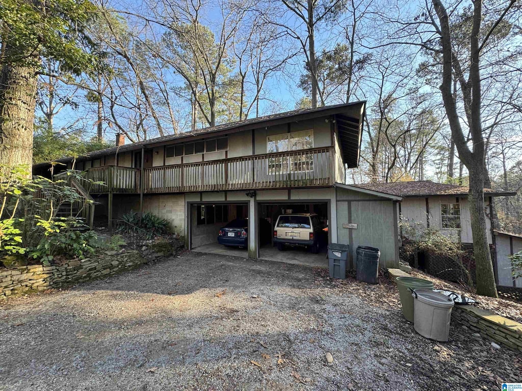 back of house with a deck and a garage