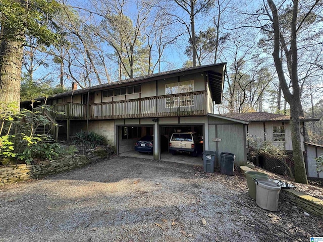 rear view of property with a garage and a wooden deck