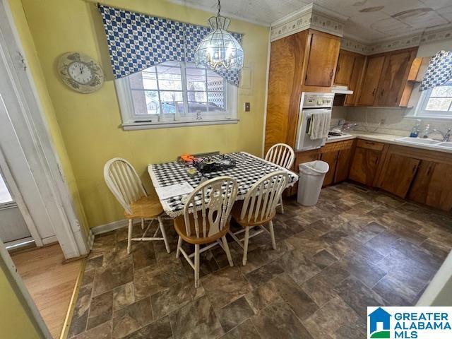 kitchen featuring sink, a notable chandelier, hanging light fixtures, and oven