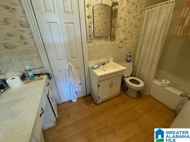 full bathroom with vanity, tile walls, and hardwood / wood-style floors