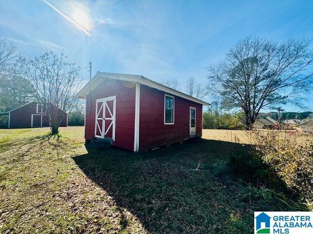 view of outbuilding featuring a lawn