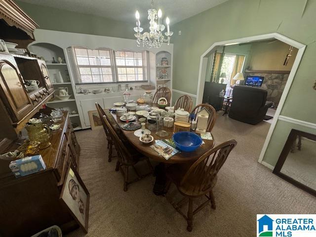 dining area featuring a notable chandelier and light carpet