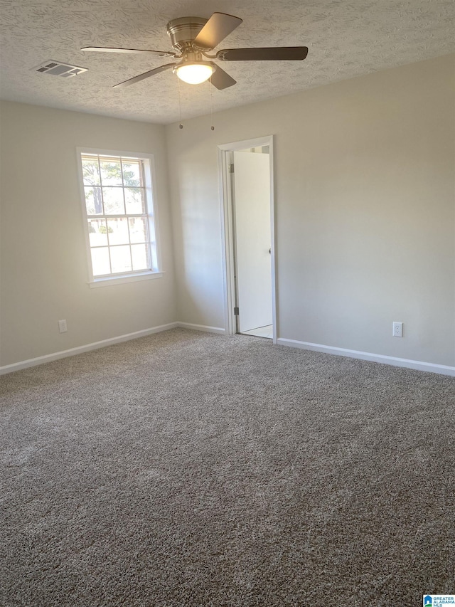 unfurnished room with a textured ceiling, ceiling fan, and carpet floors