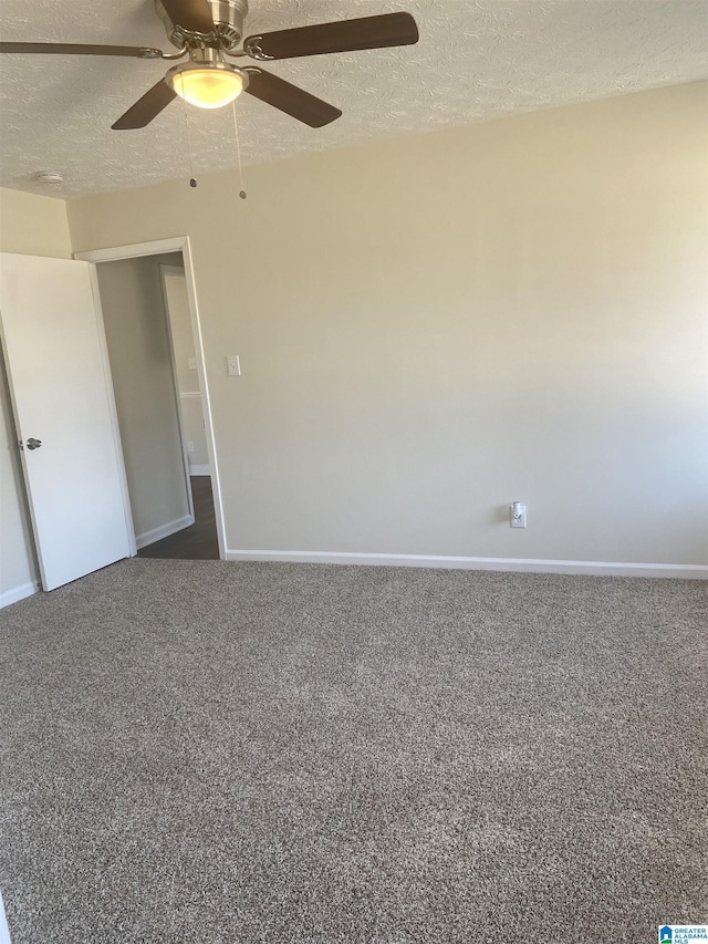 unfurnished room featuring a textured ceiling, ceiling fan, and dark carpet