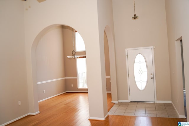 foyer entrance featuring plenty of natural light, light hardwood / wood-style flooring, and a towering ceiling