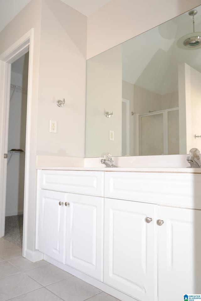 bathroom with walk in shower, vanity, and tile patterned floors