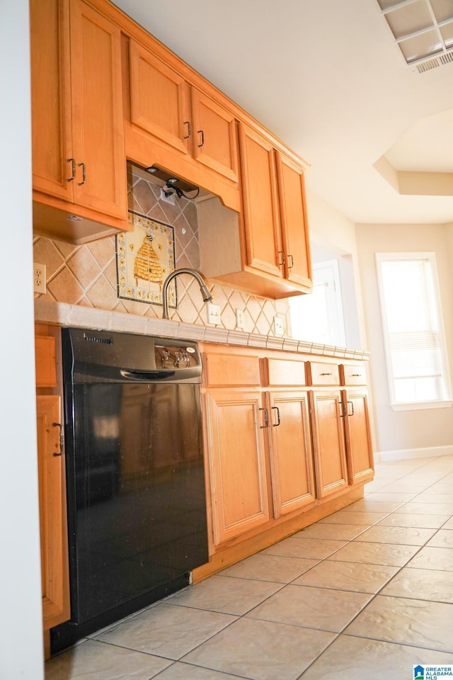 kitchen with light tile patterned flooring, tile countertops, dishwasher, and backsplash