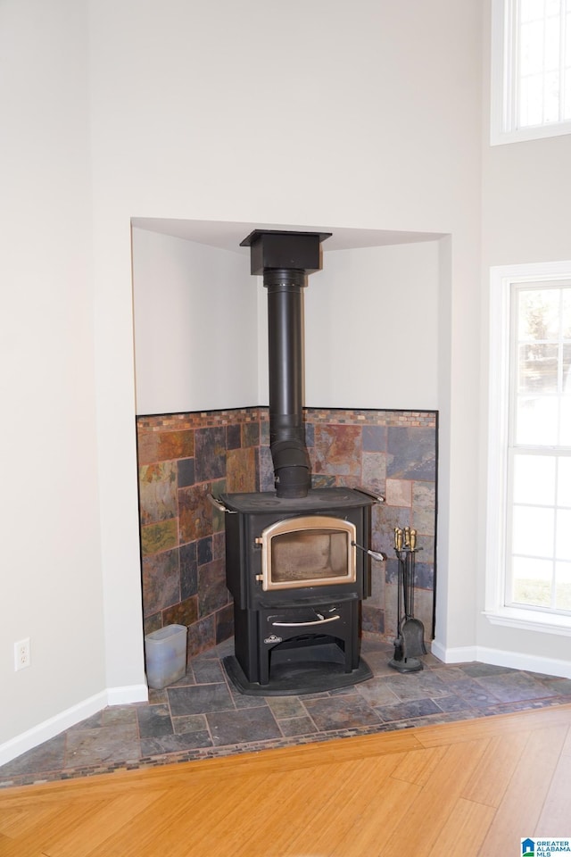 details featuring a wood stove and hardwood / wood-style flooring