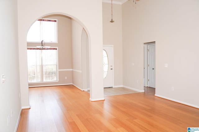 foyer entrance featuring light hardwood / wood-style floors and a towering ceiling