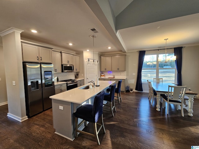 kitchen with decorative light fixtures, appliances with stainless steel finishes, gray cabinets, and lofted ceiling