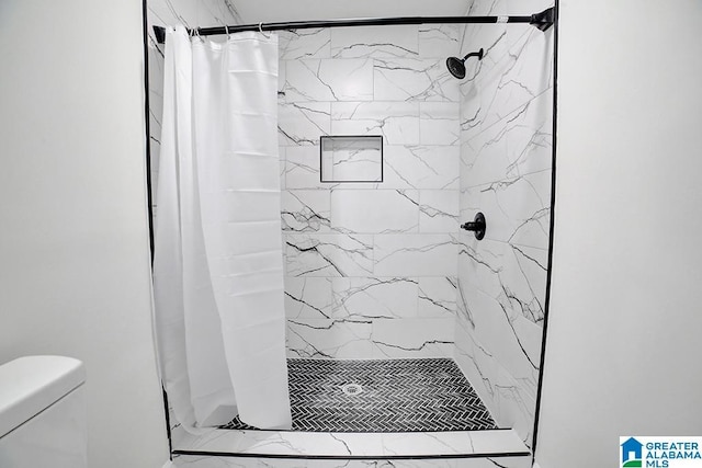 bathroom with a shower with curtain and toilet