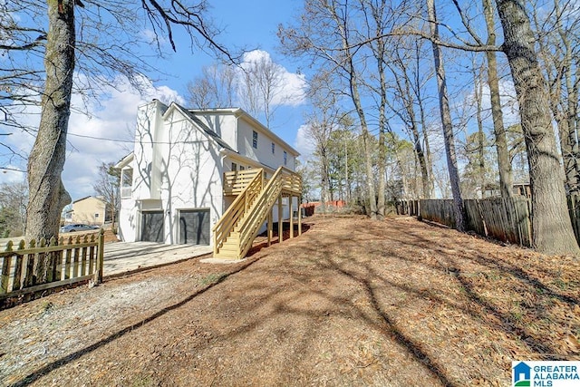 back of house with a garage and a deck