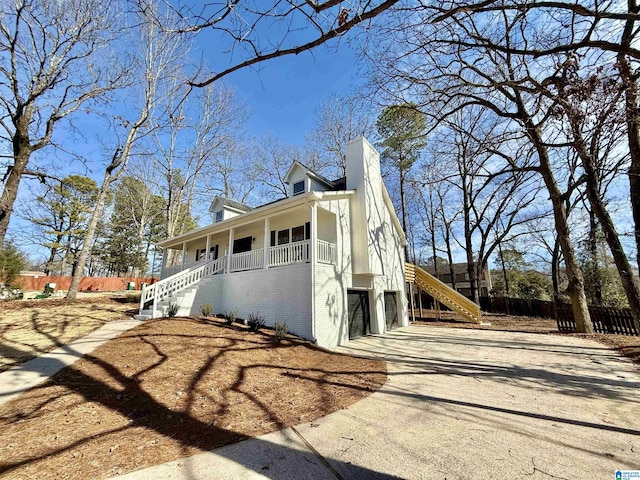 view of side of home featuring a garage and covered porch