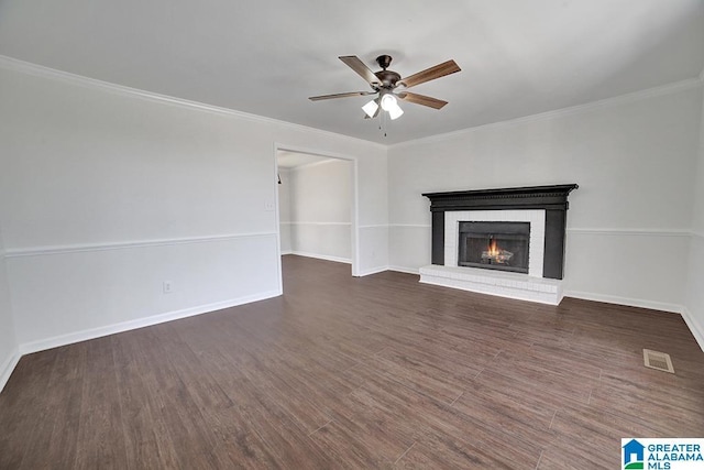 unfurnished living room with a fireplace, ceiling fan, ornamental molding, and dark hardwood / wood-style floors