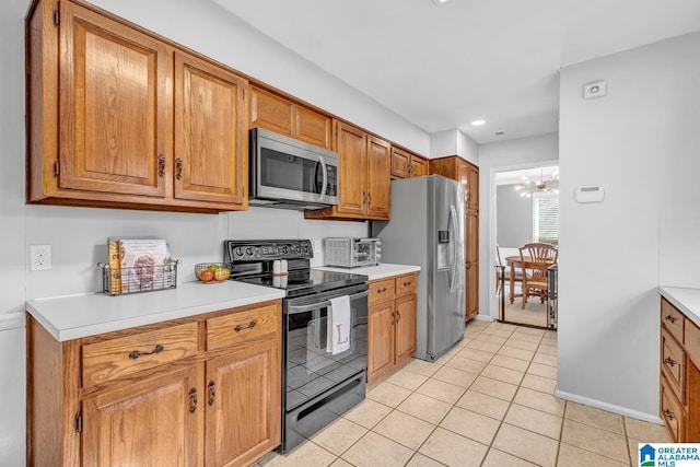 kitchen featuring appliances with stainless steel finishes, a notable chandelier, and light tile patterned floors