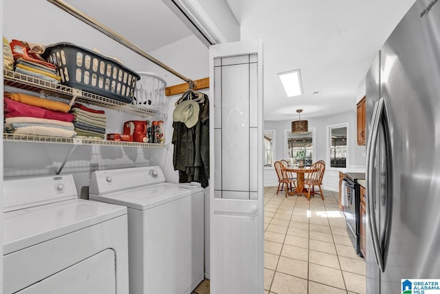 washroom featuring a skylight, light tile patterned floors, and independent washer and dryer